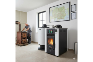 Dwóch techników w kotłowni przy starym, żeliwnym piecu i nowoczesnym, białym kotle na pellet Technix Pell Lux z wyświetlaczem. Na ścianie mapa Polski i certyfikaty. Ilustracja postępu technologicznego w ogrzewaniu.